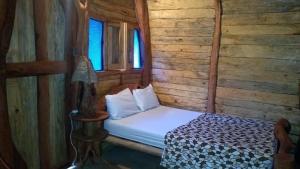 a small bed in a room with wooden walls at EL RODEO in San Gil