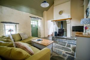 a living room with a couch and a fireplace at Carleys Cottage in Fanore