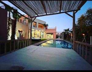 Blick auf ein Haus mit einem Pool in der Unterkunft Villa aquaparc piscine chauffée sans vis à vis in Marrakesch