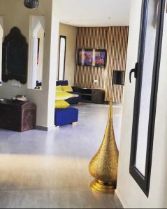 a living room with a gold vase on the floor at Villa aquaparc piscine chauffée sans vis à vis in Marrakech