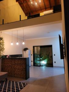 een woonkamer met een open haard en een groot raam bij BrotasLoft in Brotas