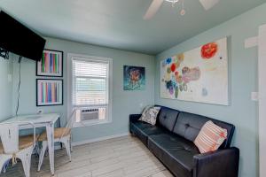 a living room with a black couch and a table at Barefoot Bungalow SPV26 in Port Aransas