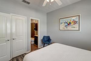 a bedroom with a bed and a blue chair at Barefoot Retreat MC15 in Port Aransas +47 photos