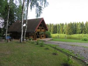 a log cabin in the woods next to a lake at Saunaga külalistemaja, Tartust 9km kaugusel 