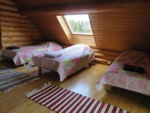 a room with three beds and a window in a cabin at Saunaga külalistemaja, Tartust 9km kaugusel 