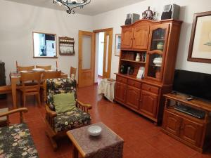 uma sala de estar com televisão e uma sala de jantar em Disfrutar y relajarse en el Robledal em Zarzuela del Monte