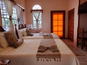 1 dormitorio grande con 2 camas y ventana en Beya Suites, en Punta Gorda