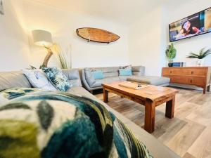 a living room with a couch and a coffee table at Palms34 5 minute walk to beach Bungalow in Westward Ho