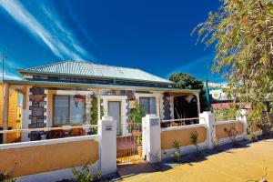 a house with a white fence in front of it at Emaroo Cottages Broken Hill in Broken Hill