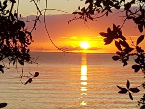 una puesta de sol sobre el océano con la puesta de sol en Beya Suites, en Punta Gorda