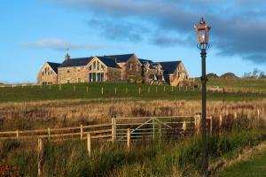 a large house in a field with a street light at Capercaillie Cottage - Luxury converted steading in Perth