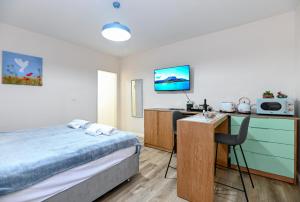 1 dormitorio con 1 cama y escritorio con microondas en The Turquoise House, en Poriyya
