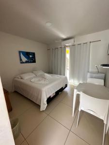 1 dormitorio con 1 cama, 1 silla y 1 mesa en Casa Temporada Suítes en Maragogi