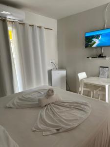 un letto bianco con un asciugamano sopra di Casa Temporada Suítes a Maragogi
