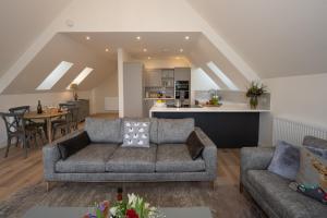 een woonkamer met een bank en een keuken bij Capercaillie Cottage - Luxury converted steading in Perth