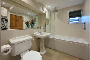 een badkamer met een toilet, een wastafel en een bad bij Capercaillie Cottage - Luxury converted steading in Perth