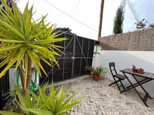 a patio with a table and chairs and a fence at IN-Cascais Suite Deluxe com pátio privado in Cascais