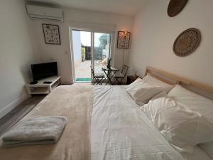 a bedroom with a large bed and a television at IN-Cascais Suite Deluxe com pátio privado in Cascais