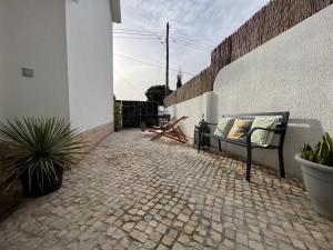 a patio with a bench on a brick courtyard at IN-Cascais Suite Deluxe com pátio privado in Cascais