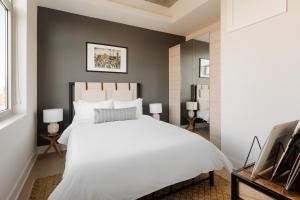 a bedroom with a white bed and a black wall at Sonder The Mint in Philadelphia