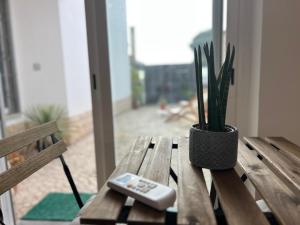 a remote control sitting on a wooden bench with a plant at IN-Cascais Suite Deluxe com pátio privado in Cascais