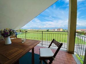 a balcony with a wooden table and chairs and a view at La casa di Aida in San Maurizio Canavese