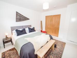 a bedroom with a large bed and a wooden door at Shore Lodge in Stornoway