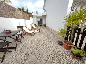 a patio with a table and chairs and potted plants at IN-Cascais Suite Deluxe com pátio privado in Cascais
