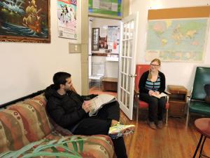 Ein Mann und eine Frau sitzen auf einer Couch in einem Zimmer in der Unterkunft St. Clair Hotel Hostel in Vancouver