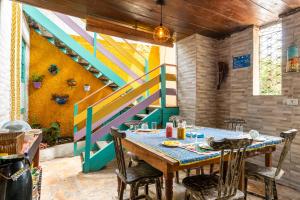 a dining room with a table and a colorful staircase at Pousada Flor de Olinda in Olinda