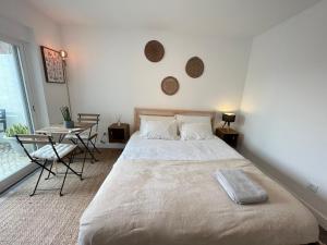 a bedroom with a large bed and a table at IN-Cascais Suite Deluxe com pátio privado in Cascais