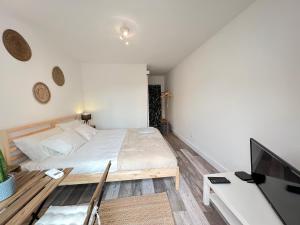 a bedroom with a bed and a desk with a tv at IN-Cascais Suite Deluxe com pátio privado in Cascais