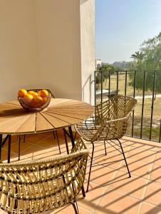 una mesa y sillas con un bol de fruta en el balcón en Hacienda Riquelme Charming Apartment, en Sucina