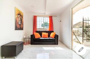 uma sala de estar com um sofá preto com almofadas laranja em Hostal-Mirador La Popa em Cartagena de Indias