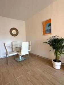 a room with a table and chairs and a plant at Superbe appartement neuf - 5min beach walk in Nice
