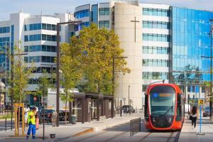 a red tram on a city street with buildings at Superbe appartement neuf - 5min beach walk in Nice