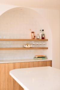 a kitchen with a white counter and shelves at Entre Palmas Ballina in Ballina