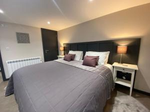 a bedroom with a large bed with purple pillows at The Courtyard Apartment in Brampton