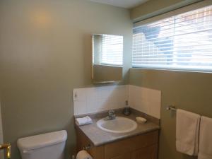 La salle de bains est pourvue d'un lavabo, de toilettes et d'un miroir. dans l'établissement Caruso's Accommodation, à Jasper