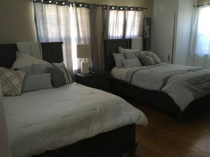 two beds sitting in a bedroom with windows at beautiful house in the hills in Altadena