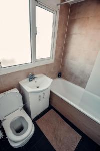 a bathroom with a toilet and a tub and a sink at Comfy Home-Wood Green in London