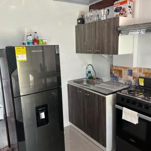 a kitchen with a stainless steel refrigerator and a sink at Cabaña confortable y familiar in Coveñas