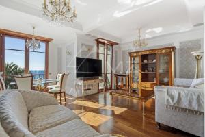 a living room with a couch and a tv at Luxury apartment with sea view on the first line Promenade des Anglais in Nice