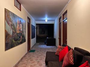 una sala de estar con sofá y una pintura en la pared en La Rivera de Gocta, en Cocachimba