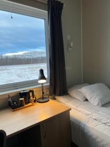 a bedroom with a bed and a desk with a window at Kiruna City Room in Kiruna