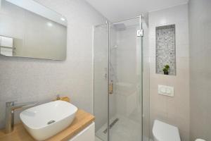 a bathroom with a sink and a glass shower at Solaris Lux Apartments in Kotor