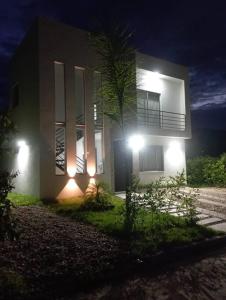 Hermosa casa vacacional en Condominio campestre في كارمن دي أبيكالا: منزل فيه اضاءه في الليل