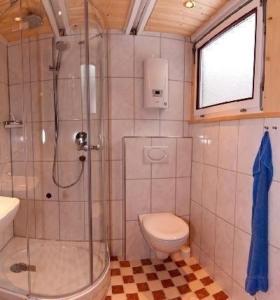 y baño con ducha, aseo y lavamanos. en Nur-Dach-Ferienhaus für vier Personen, en Neuhausen