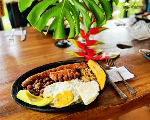 a plate of breakfast food on a wooden table at Finca La Colmena De Don Juaco in Montenegro