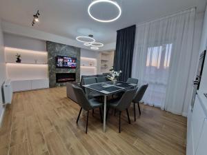a dining room with a table and chairs and a fireplace at Dendrarium Park Apartment Deluxe in Chişinău